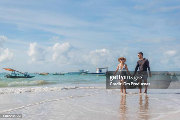 pareja de turistas caminando por la playa - porto galinhas fotografías e imágenes de stock