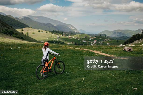 cyclist with helmet holds her bicycle and looks at the valley - transylvania romania stock pictures, royalty-free photos & images