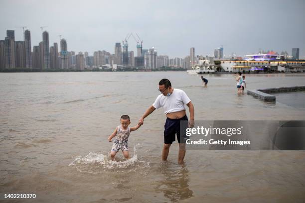 Rsidents play in the flooded Jiangtan park caused by the Yangtze river on June 10, 2022 in Wuhan, Hubei province, China. According to local media...