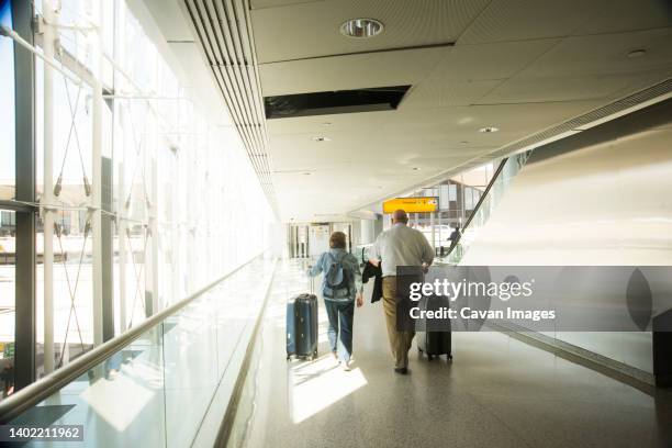 senior couple walking through airport - carry on bag bildbanksfoton och bilder