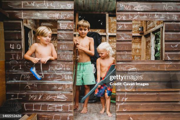 smiling siblings using imagination to play with random toys outside - playhouse stock pictures, royalty-free photos & images