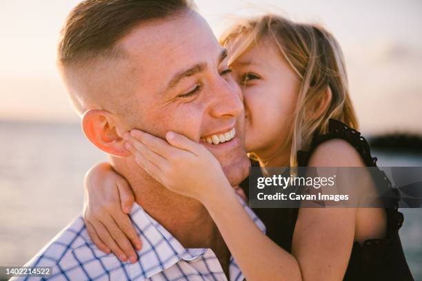 5 year old daughter gives father a kiss on the cheek by ocean - 2 year old blonde girl father ストックフォトと画像
