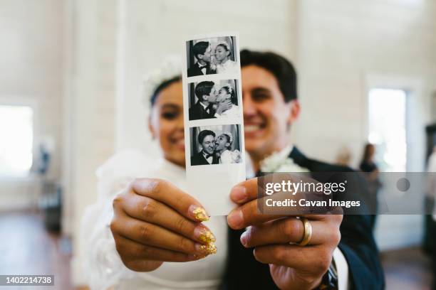 bride and groom smile holding polaroid photograph of them - utah wedding stock pictures, royalty-free photos & images