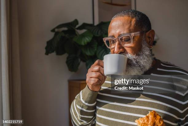 senior hipster man drinking coffee in cup at home - kaffee trinken stock-fotos und bilder