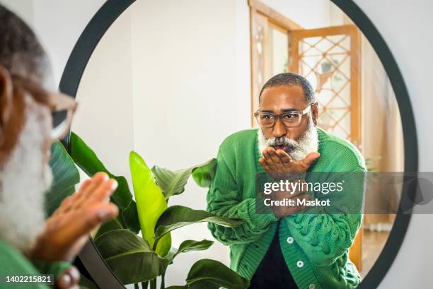 hipster man blowing kiss while looking in mirror at home - kissing mirror stock pictures, royalty-free photos & images