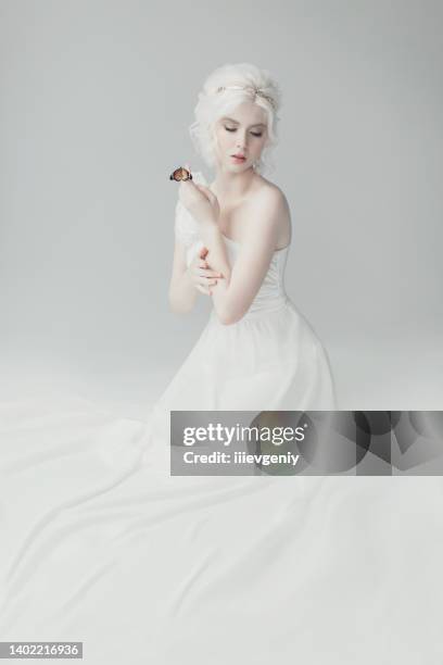 jovem modelo loira no estúdio. mulher com lindo penteado grego luxuoso em vestido branco. garota com borboleta na mão. coroa dourada. albino. retrato de beleza. deusa grega. pureza e inocência - goddess - fotografias e filmes do acervo