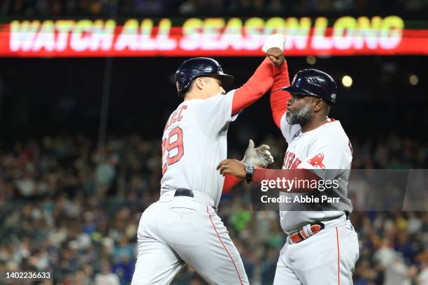 Bobby Dalbec of the Boston Red Sox celebrates with third base coach Carlos Febles after hitting a solo home run against the Seattle Mariners to take...