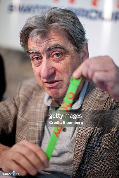 Nick Hayek, chief executive officer of Swatch Group AG, holds a wristwatch with the word 'occupy' on it during the company's results news conference...