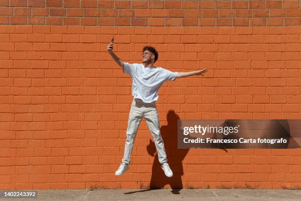 man jumping and taking a selfie - セルフィー　男性 ストックフォトと画像