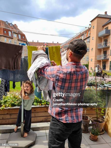 fatherhood: giving a hand with laundry - courtyard stock pictures, royalty-free photos & images