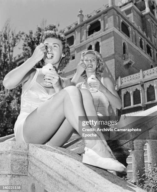 Marilyn Marsh and Charmaine Casey, two of the Merriel Abbott Dancers, eating ice creams in front of the Hotel Excelsior, on the Venice Lido, Italy,...