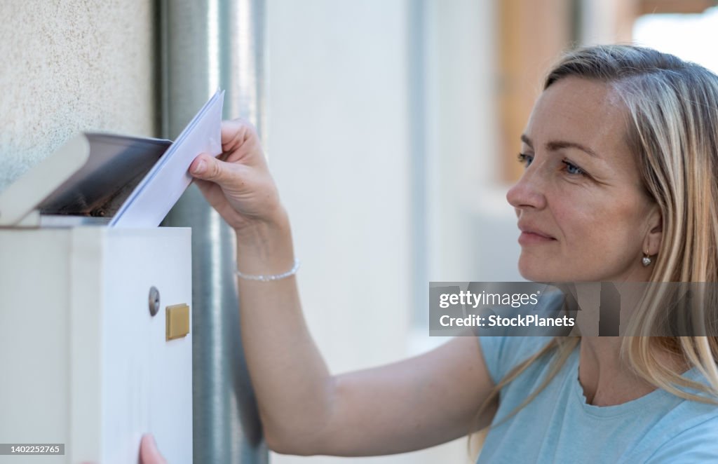 Woman picking up mail from mailbox