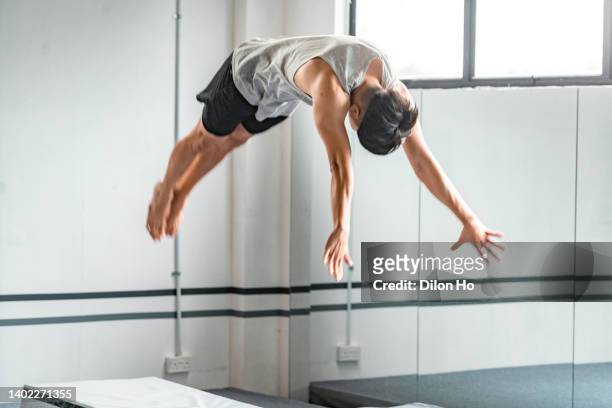 asian man acrobatic dive - stunt person stock pictures, royalty-free photos & images