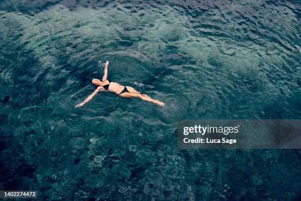 female enjoying a relaxing sea swim in ibiza - floating on water stock pictures, royalty-free photos & images