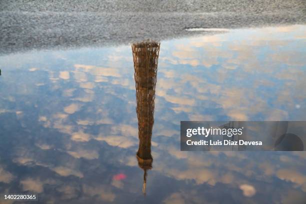 reflection of the eiffel tower in a puddle of water - puddle stock pictures, royalty-free photos & images