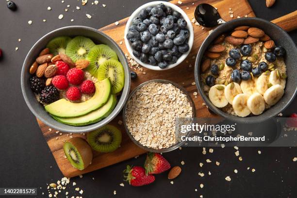 bowls of oatmeal with mixed fruits topping - berry stockfoto's en -beelden