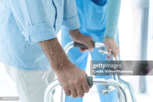 home healthcare for asian nurse helping senior patient using walker assistance at home. - physiotherapy asian stock pictures, royalty-free photos & images