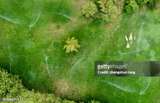 watering the lawn of sloping fields, aerial view - sprinkler system stock pictures, royalty-free photos & images