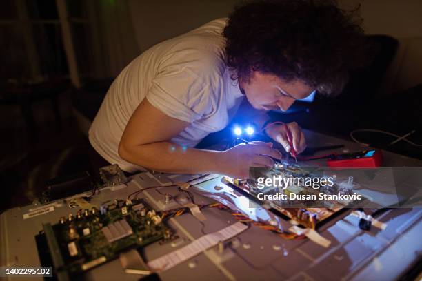 young man repairing smart tv - insight tv stockfoto's en -beelden