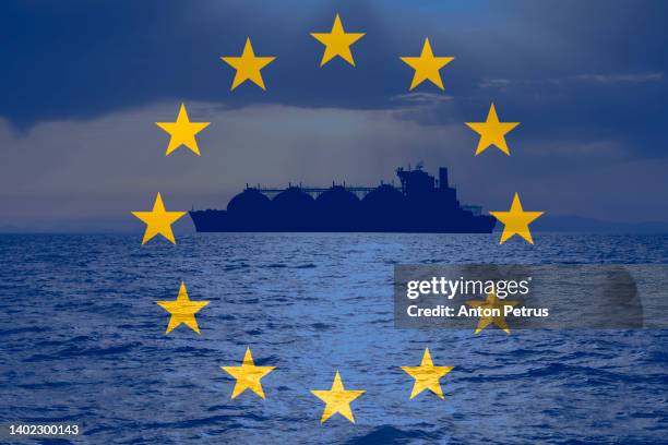 lng carrier on the background of the eu flag. energy crisis in europe - storage tank stock-fotos und bilder