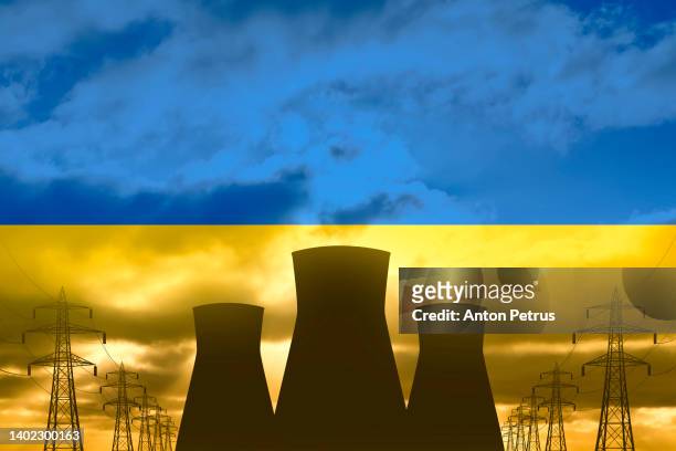 nuclear power plant on the background of flag of ukraine. nuclear power industry in ukraine - ukraine war stock pictures, royalty-free photos & images