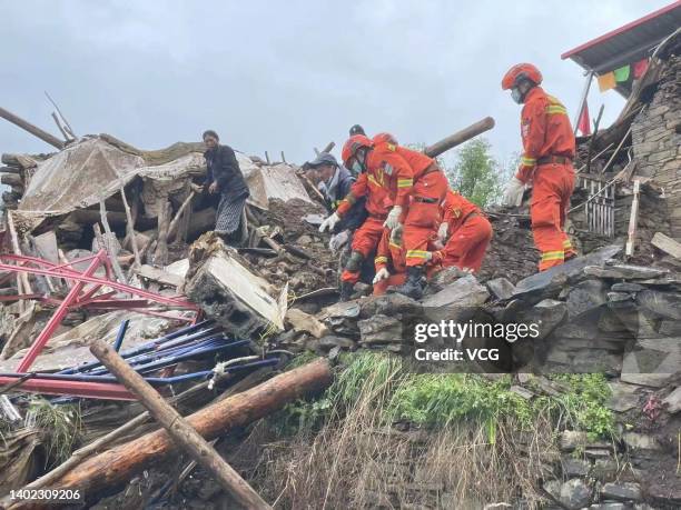 Rescuers search for belongings for villagers from a collapsed house on June 11, 2022 in Barkam, Aba Tibetan and Qiang Autonomous Prefecture, Sichuan...