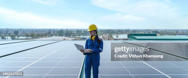 female engineer at energy solar panel roof. - hochspannungstransformator stock-fotos und bilder