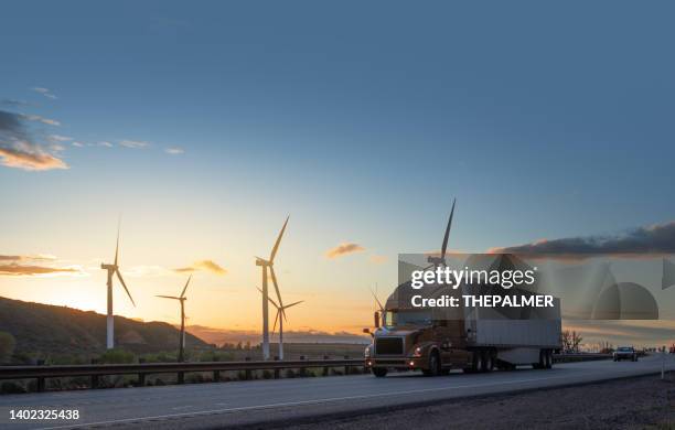 semirremolque a toda velocidad frente a turbinas eólicas en utah, ee. uu. - transportation fotografías e imágenes de stock