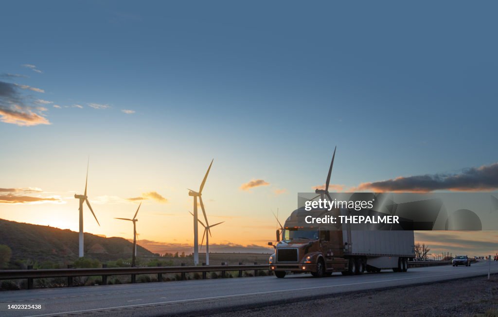 米国ユタ州の風力タービンの前でスピード違反するセミトラック