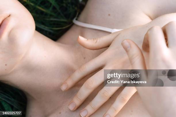 close-up of tender woman skin, fingers touching shoulders - body woman stock-fotos und bilder