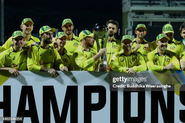 Aaron Finch of Australia holds the trophy with teammates celebrating winning the 2-1 series lead during the 3rd match in the T20 International series...