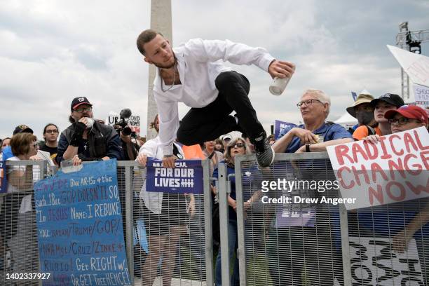 Counter-protester jumps a barricade in an attempt to disrupt a March for Our Lives rally against gun violence on the National Mall June 11, 2022 in...