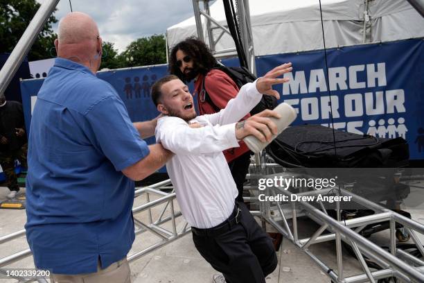 Counter-protester is detained after jumping a barricade in an attempt to disrupt a March for Our Lives rally against gun violence on the National...