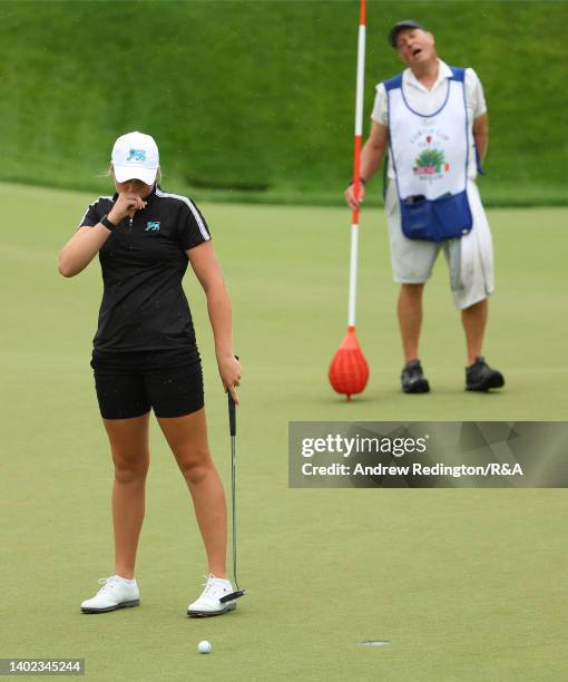 Hannah Darling of Team Great Britain and Ireland and her caddie react after missing a putt to extend the match on the 17th hole during the Morning...