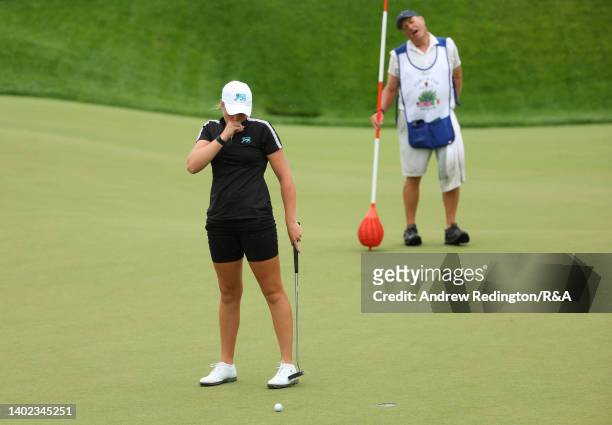 Hannah Darling of Team Great Britain and Ireland and her caddie react after missing a putt to extend the match on the 17th hole during the Morning...