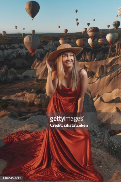 young woman in cappadocia. colorful hot air balloons flying in the air - cappadocia stock pictures, royalty-free photos & images