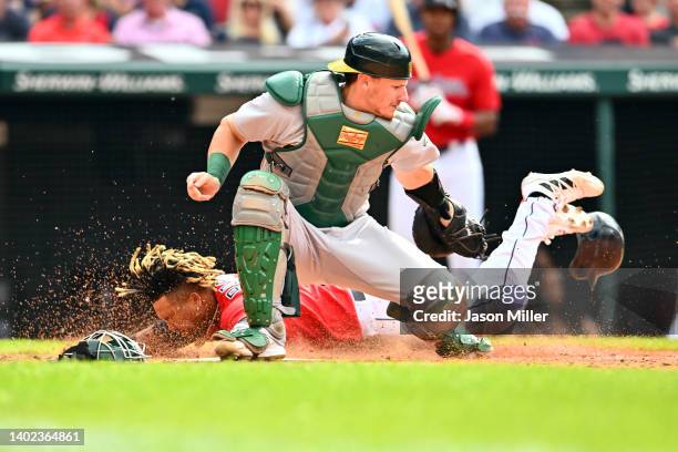 Catcher Sean Murphy of the Oakland Athletics misses the tag as Jose Ramirez of the Cleveland Guardians scores during the fourth inning at Progressive...