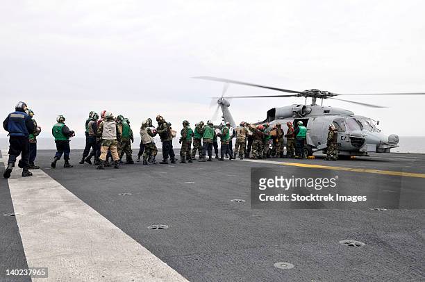 sailors and marines load supplies onto a hh-60h seahawk. - 人道支援 ストックフォトと画像