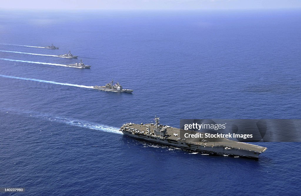 Military ships operate in formation in the South China Sea.