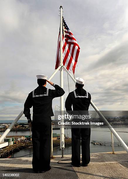 sailors raise the national ensign aboard uss abraham lincoln. - navy stock-fotos und bilder