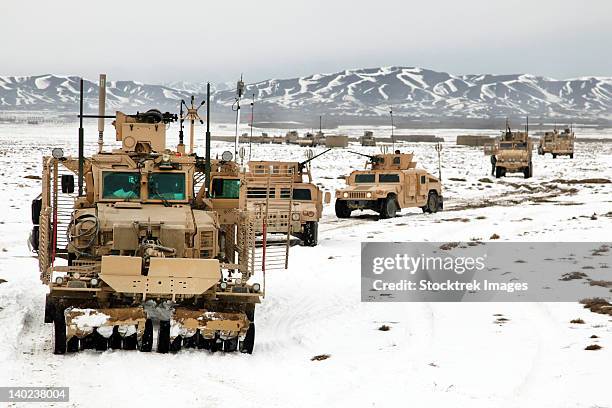 a convoy of vehicles during a route clearing procedure in afghanistan. - military convoy imagens e fotografias de stock