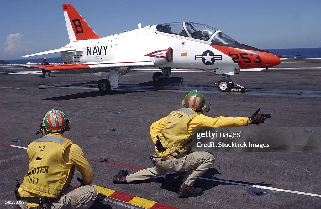 A shooter signlas the launch of a T-45A Goshawk trainer aircraft.