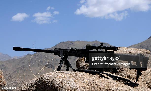 a barrett .50-caliber m107 sniper rifle sits atop an observation point in afghanistan. - 50 caliber sniper rifle stock-fotos und bilder