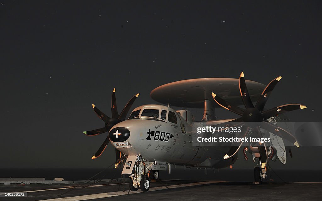An E-2C Hawkeye is chained to the flight deck aboard USS Abraham Lincoln.