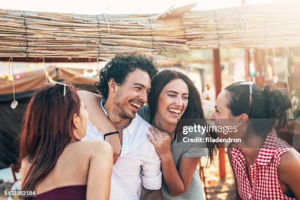 amici in un campo da spiaggia - maschio con gruppo di femmine foto e immagini stock