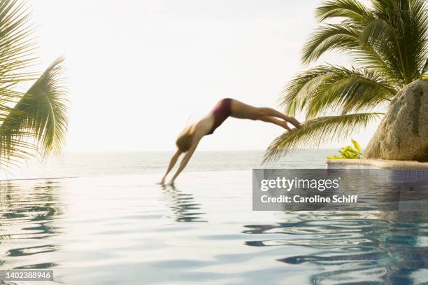 a woman diving into a pool - schiff hotel stock pictures, royalty-free photos & images