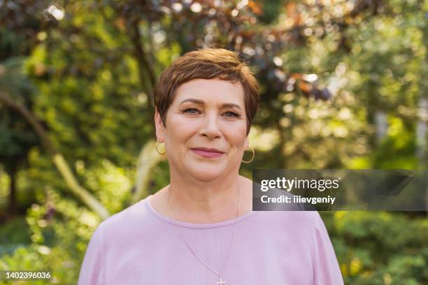 portrait of an adult woman on summer blurred background. age - women short hair stock pictures, royalty-free photos & images