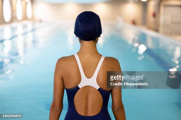 female swimmer sitting on the edge of the pool - aquatic therapy stockfoto's en -beelden