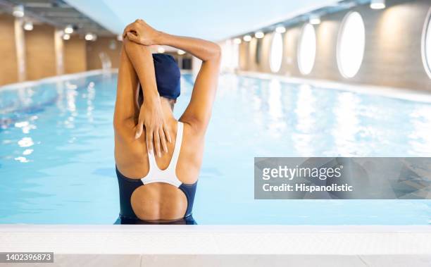 swimmer stretching her arms in the swimming pool - aquatic therapy stockfoto's en -beelden