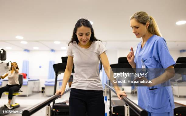 paciente em fisioterapia andando nas barras paralelas - terapia ocupacional - fotografias e filmes do acervo